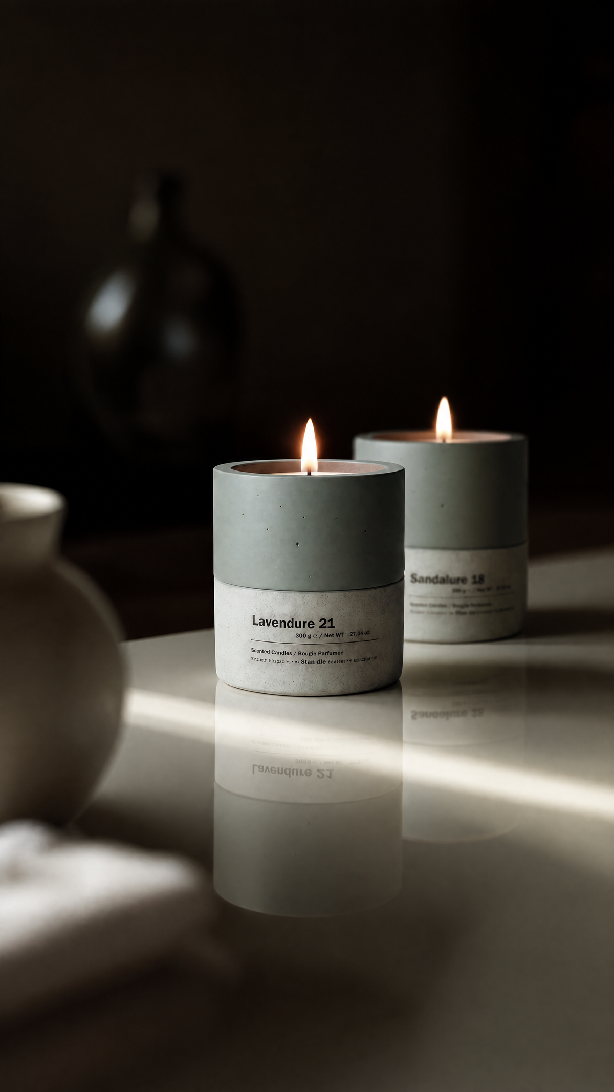 Concrete candle beside a glass jar candle — material comparison