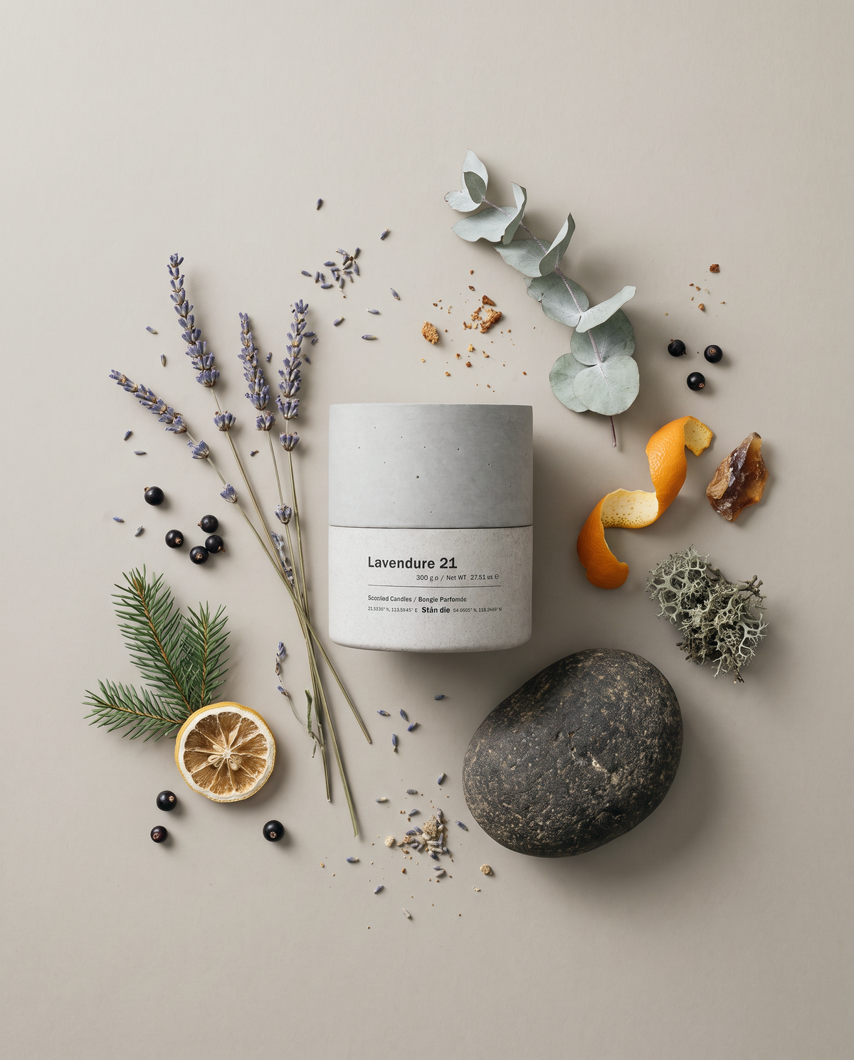 Overhead flatlay of the Lavendure 21 concrete soy candle by Stāndle surrounded by its scent notes — lavender, eucalyptus, fir, blackcurrant, dried citrus, amber resin and oakmoss — with a dark river stone.