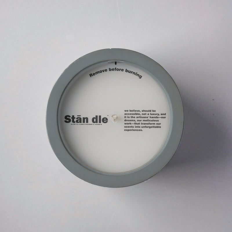 Top view of candle lid with brand logo and artisan-crafted message