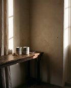 Stāndle Duo set — Sandalure 18 and Lavendure 21 concrete soy candles side by side on a wood console, with palo santo and a dried lavender sprig.